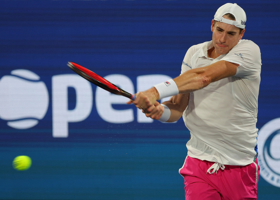 John Isner returning a backhand to Jenson Brooksby during the Atlanta Open at Atlantic Station on July 29, 2022