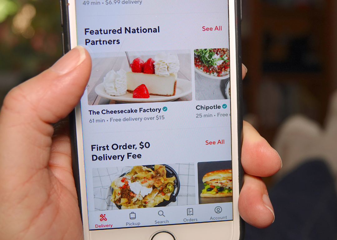 A person at home, using the DoorDash app to order food.
