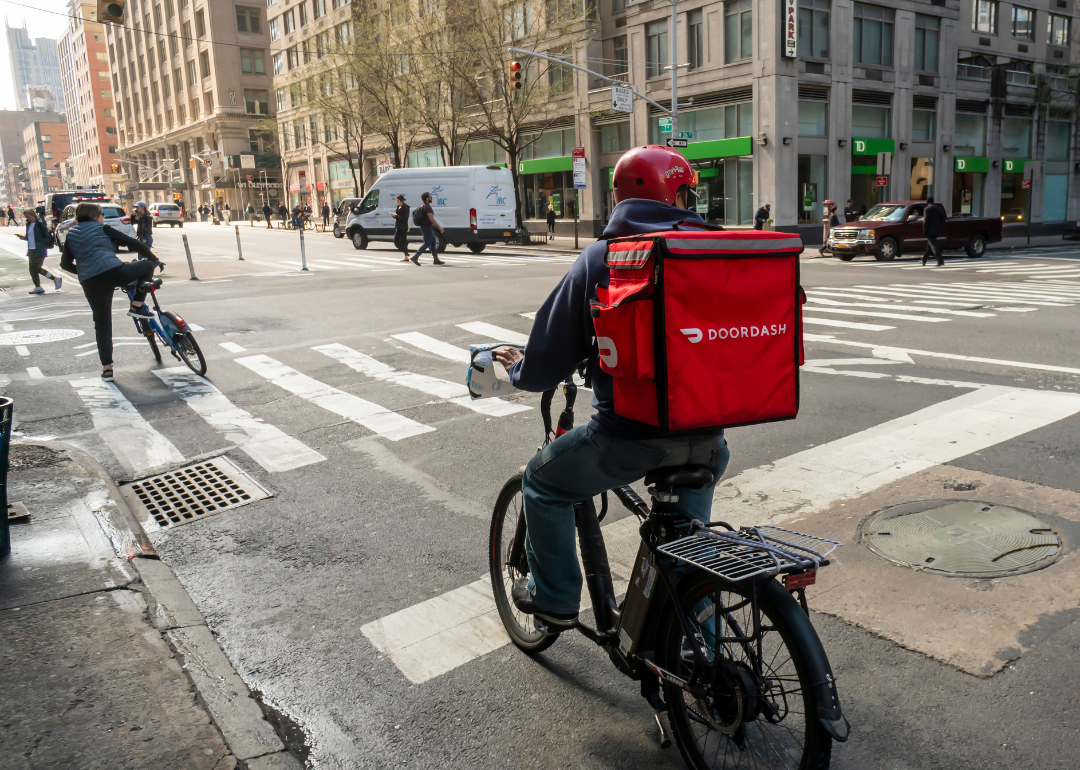 A delivery person with a DoorDash branded tote on their bicycle in the Chelsea neighborhood of New York