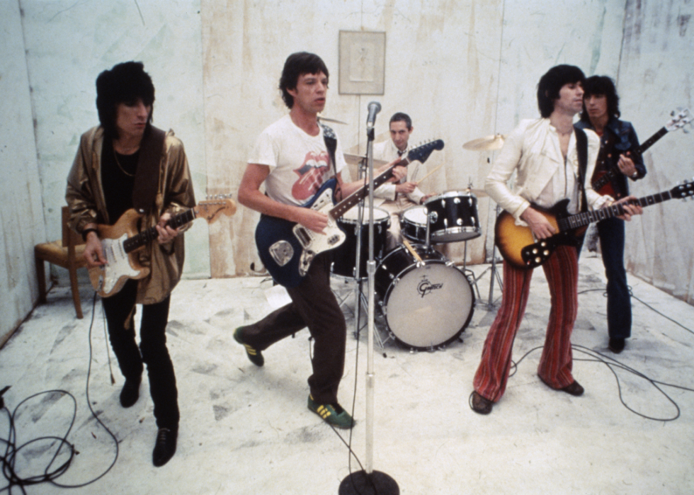The Rolling Stones in performance on a white set.