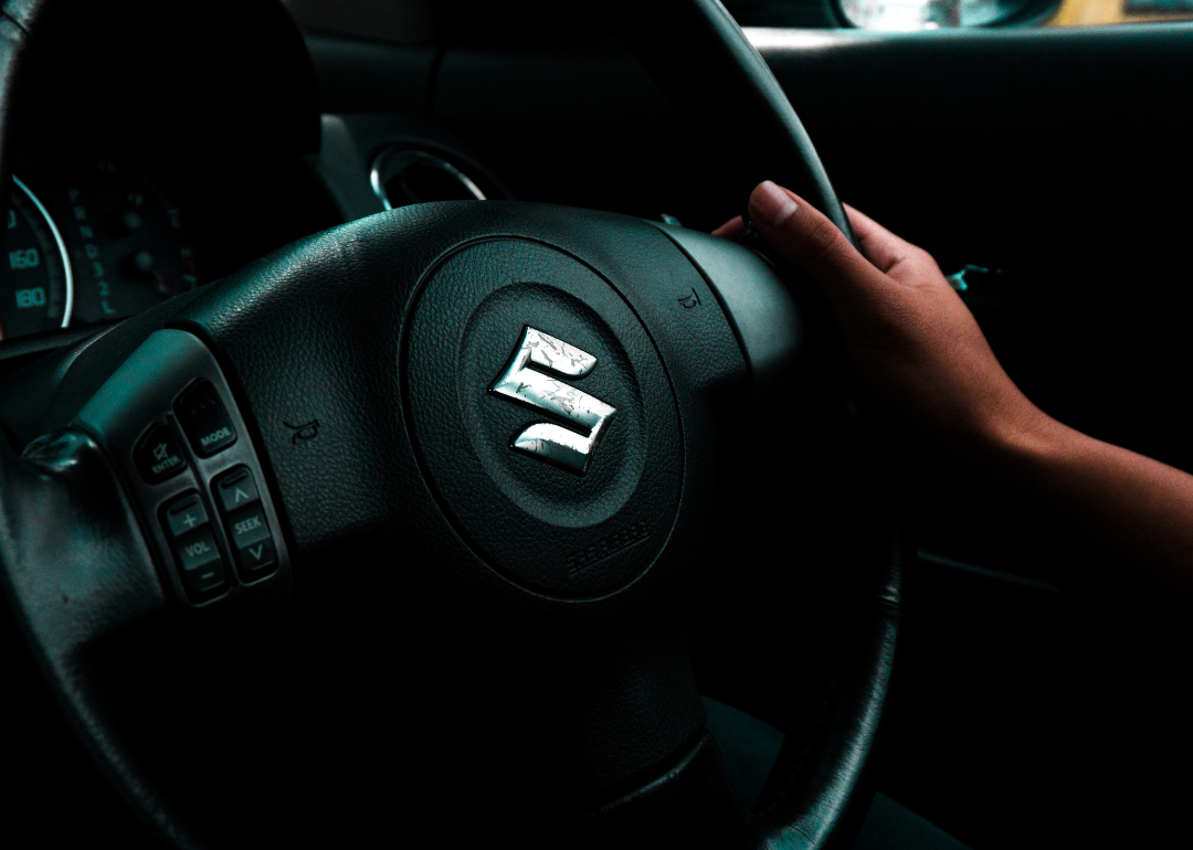 The Suzuki logo on a steering wheel.