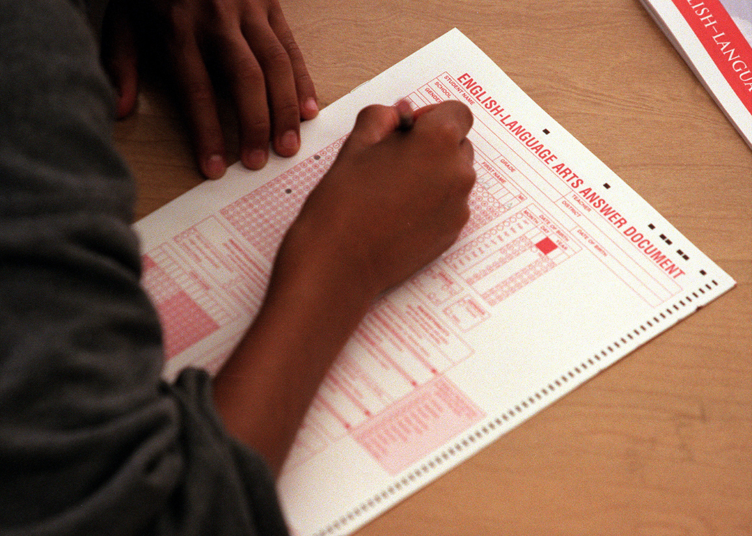 A close-up of a student filling out a scantron sheet.