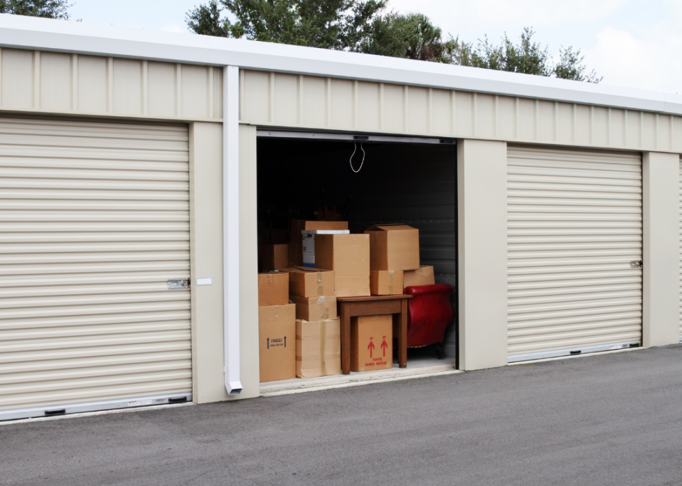 A self storage warehouse with a single storage unit full of boxes and furniture