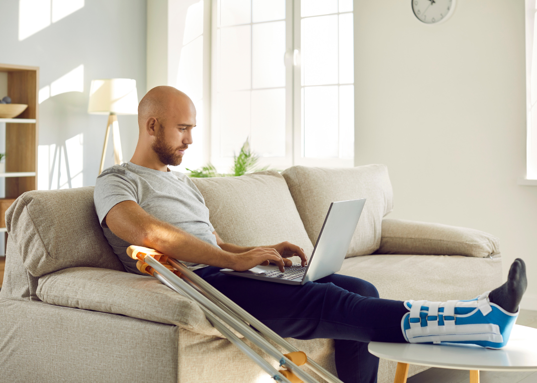 A person with a broken foot working remotely at home
