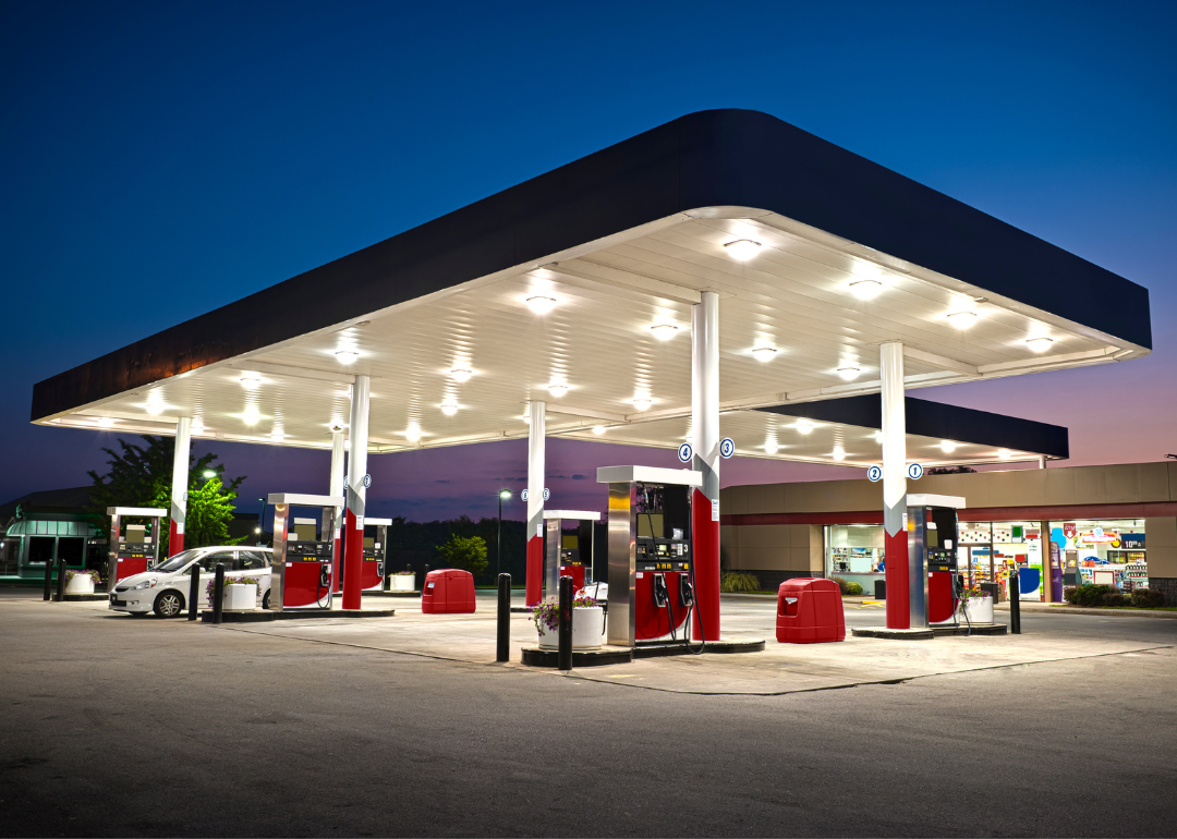 A gas station and convenience store with one car at a pump.