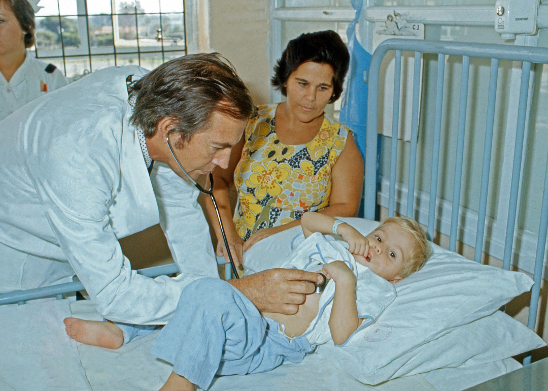 A cardiac surgeon examining a child at a hospital in 1974.