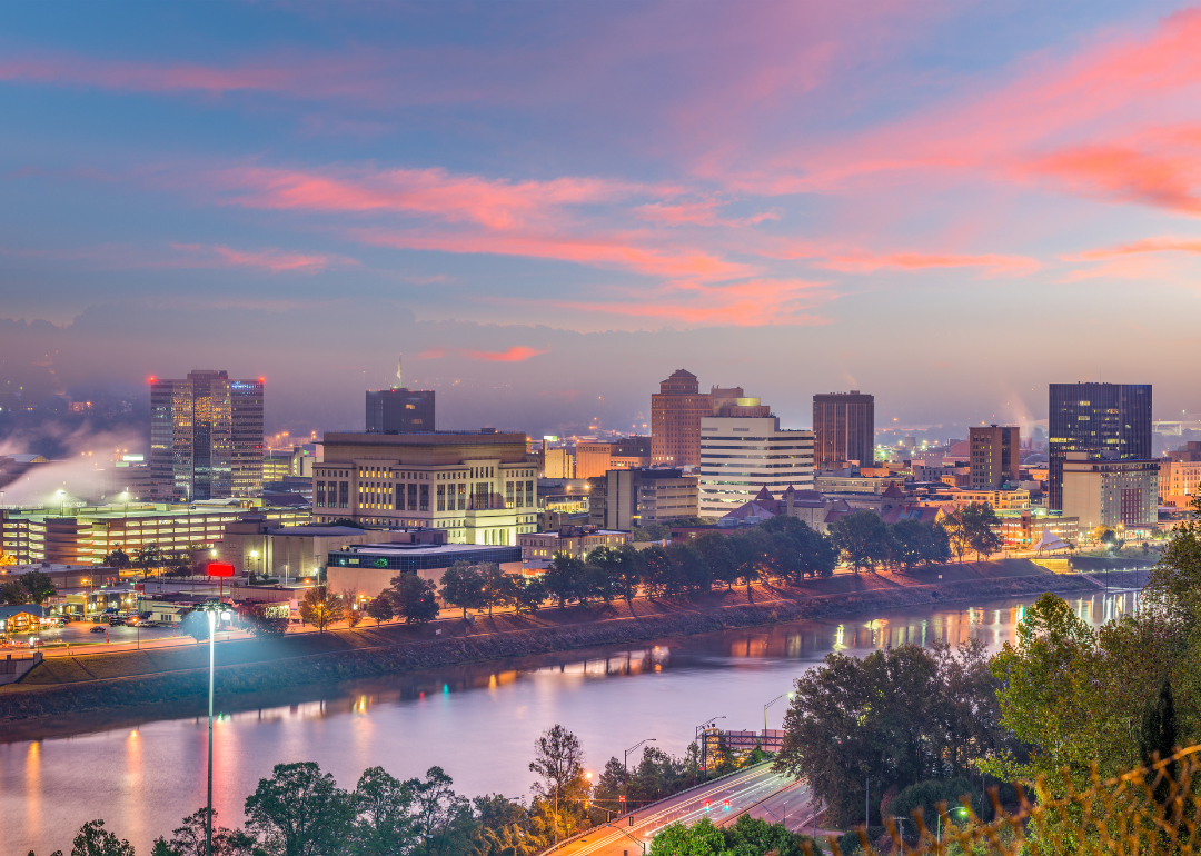 Charleston's skyline as viewed from across a river at sunset.