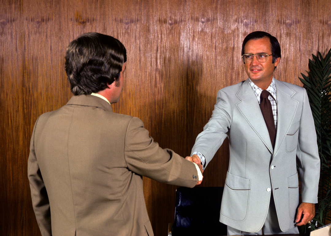 Two people shaking hands at the office in 1975.