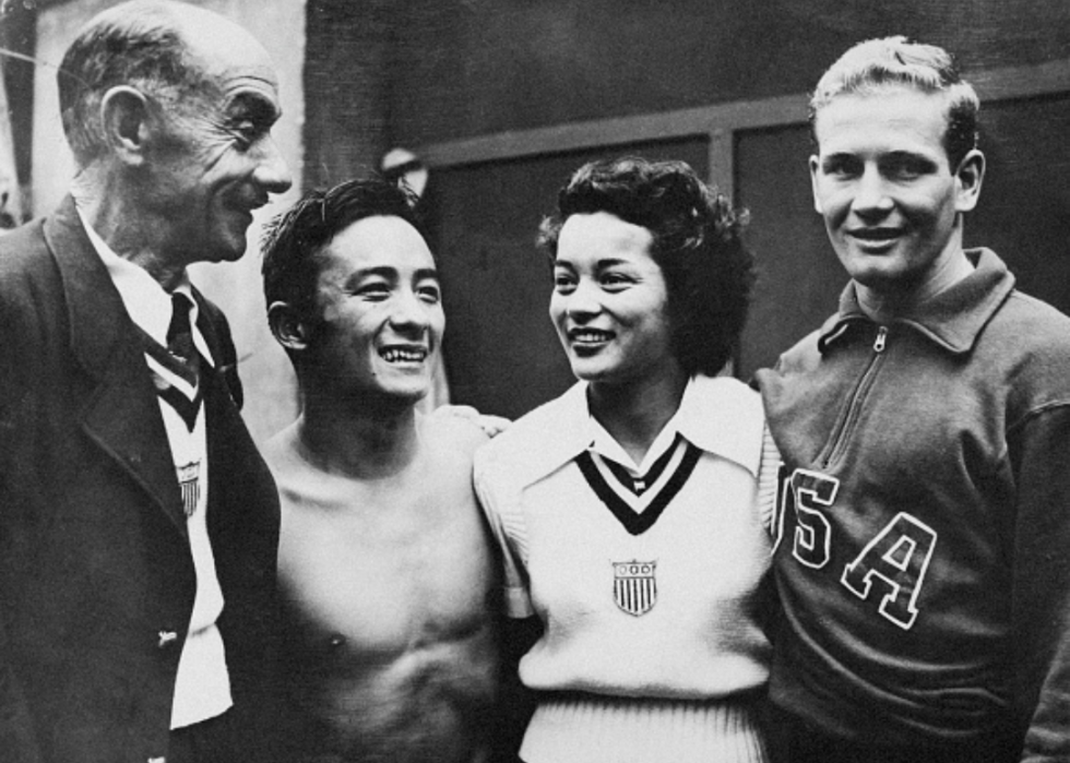Vicky Draves poses with her coach and two other athletes at the 1948 London Olympics.
