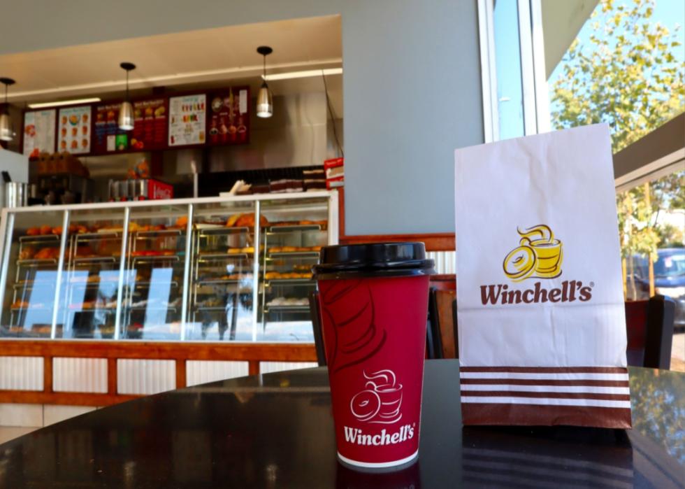 A coffee and breakfast bag on the counter at Winchell's.