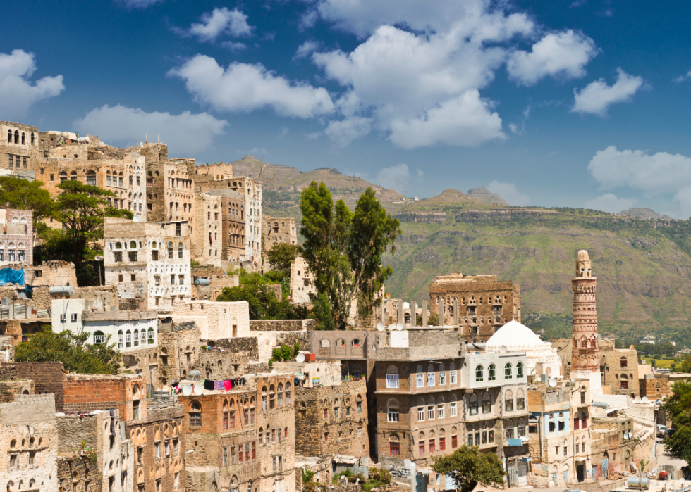 Wide view of traditional, older buildings on a hillside in Yemen.