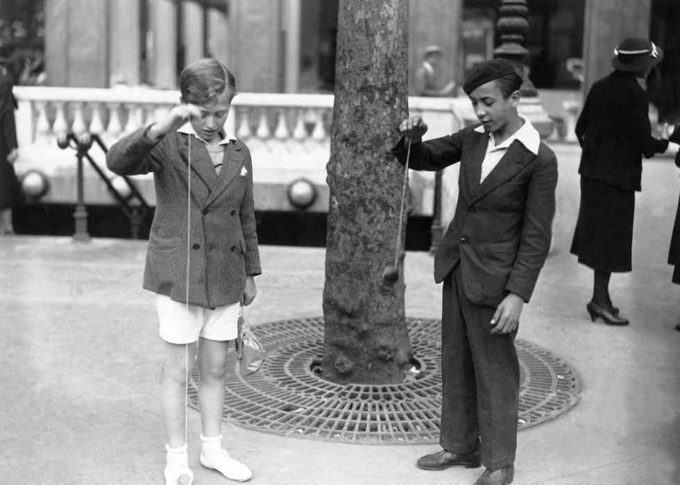 Two children playing with yo-yos around 1930.