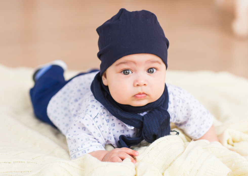 A baby boy with blue eyes and blue hat. 