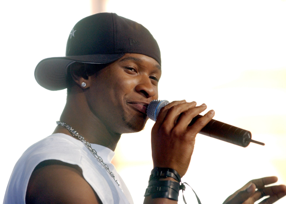 Usher smiles with microphone.