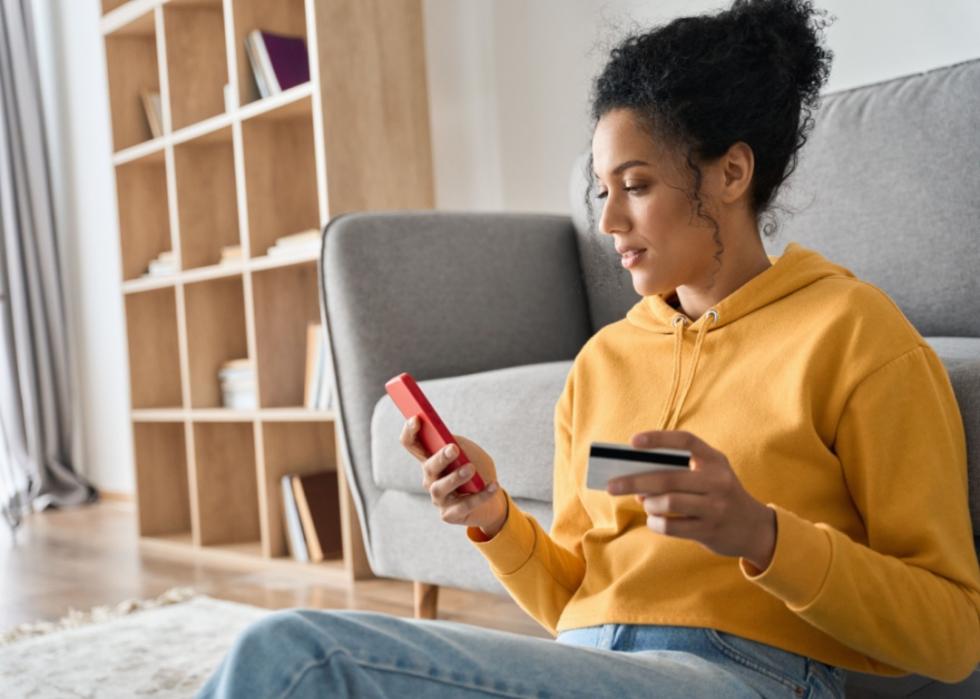 A woman holding a credit card on the phone.