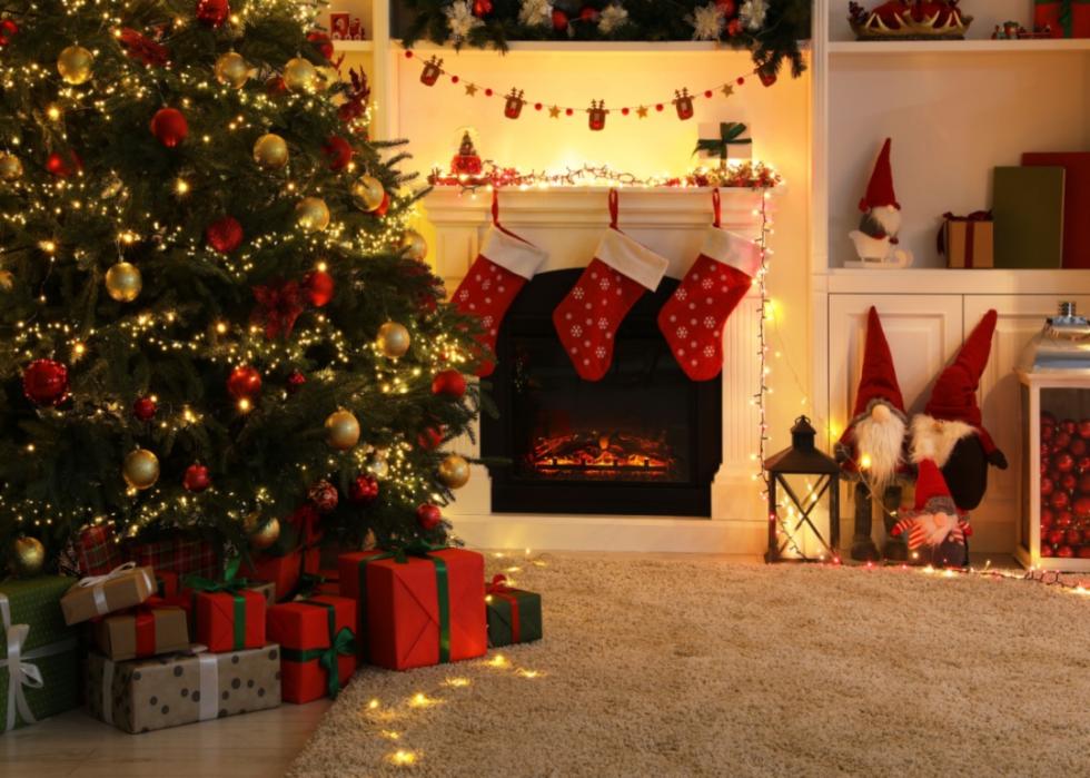 A Christmas tree with lights and presents in a decorated living room.