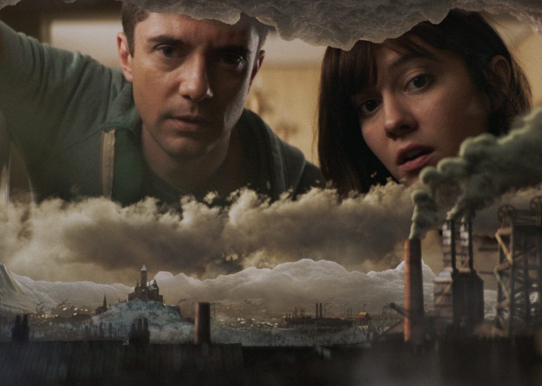 Topher Grace and Mary Elizabeth Winstead looking through a hole that becomes a city.