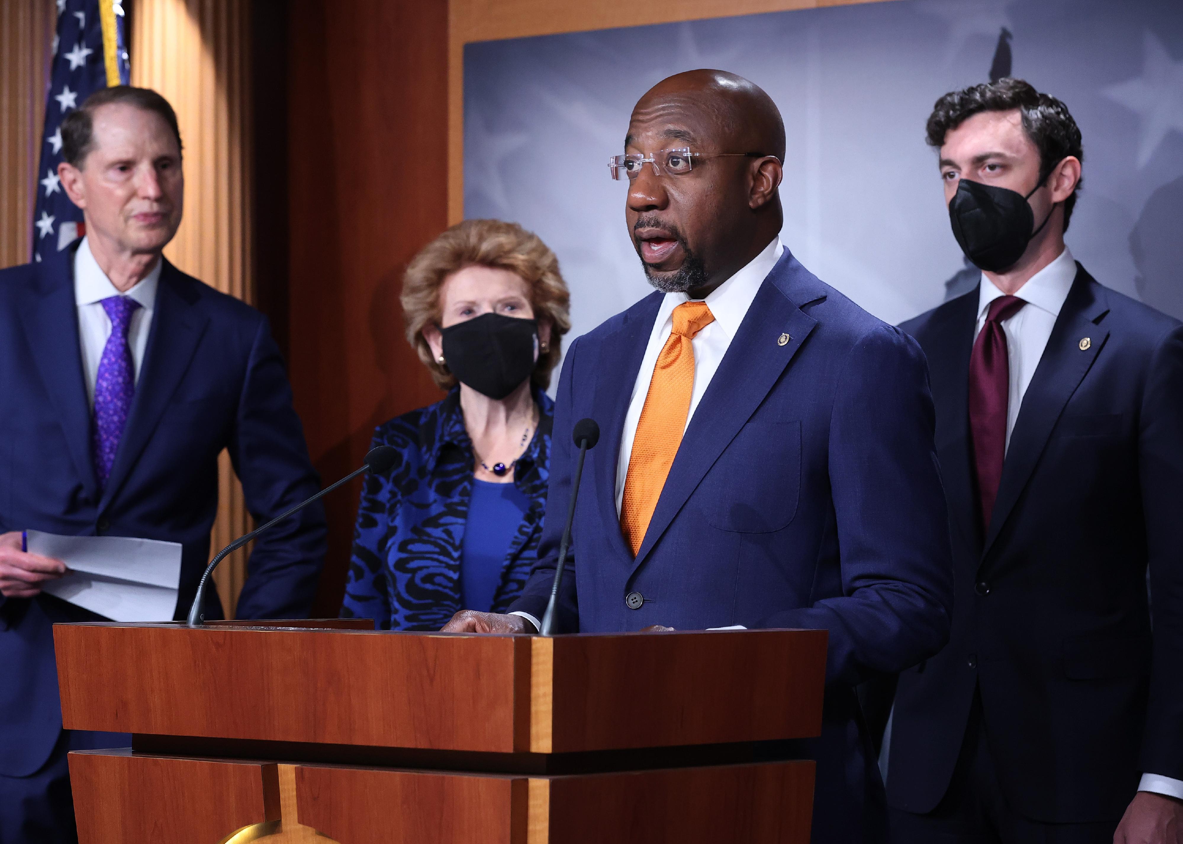 Sen. Raphael Warnock, Ron Wyden, Debbie Stabenow and Sen. Jon Ossoff and other members of Congress hold a news conference for a solar tax credit at the U.S. Capitol.