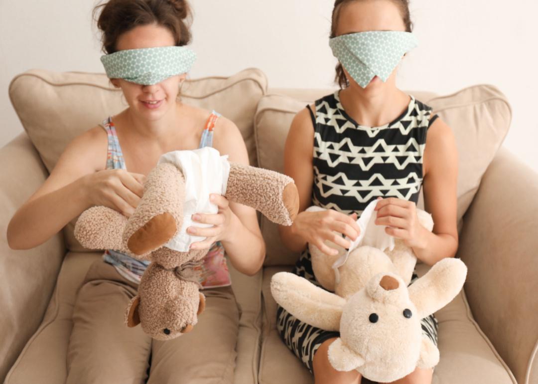 Women putting diapers on stuffed bears.