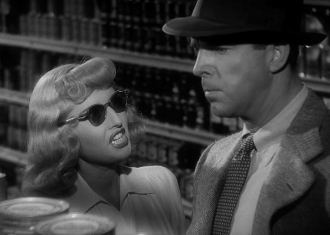 A blonde woman in dark sunglasses yelling at a man.