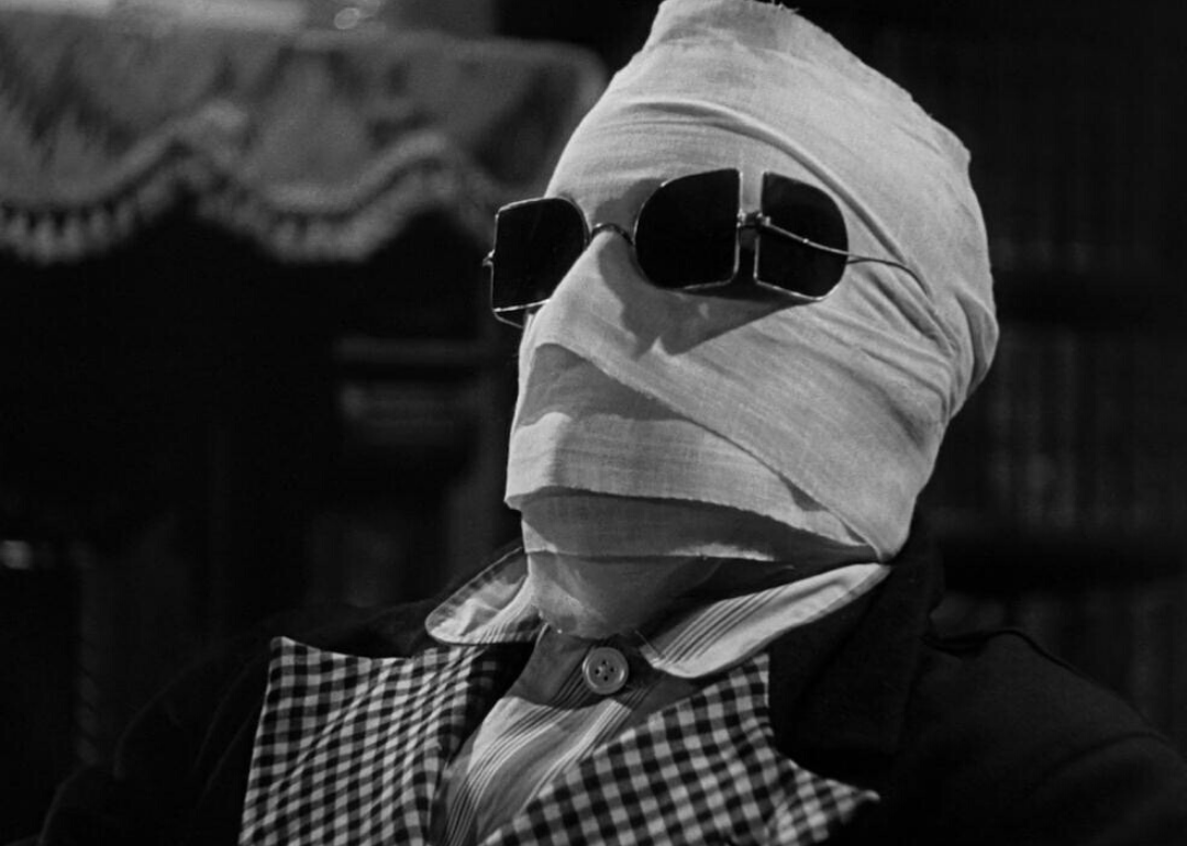 A person completely covered with a suit on and cloth wraps all around his head with sunglasses on his eyes.