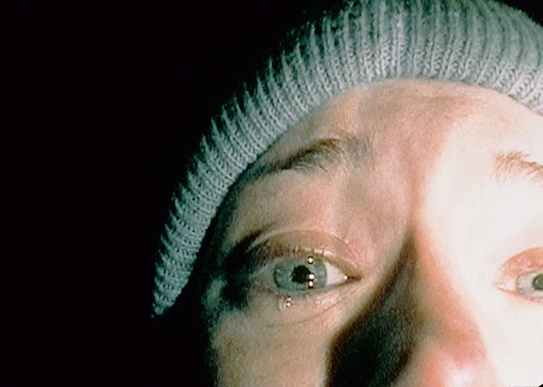 An extreme closeup of a crying woman's face in the dark.