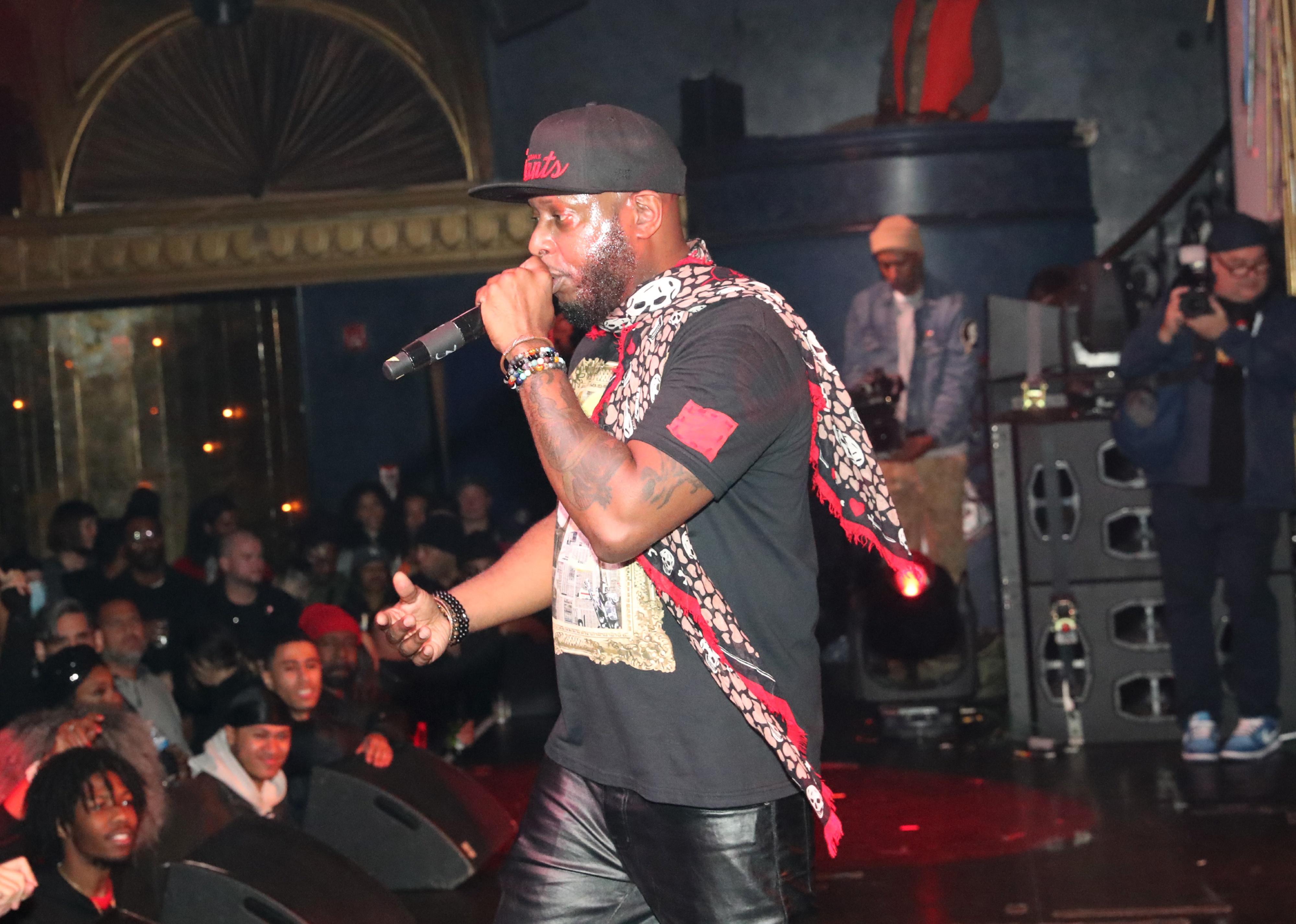 Talib Kweli performing onstage.