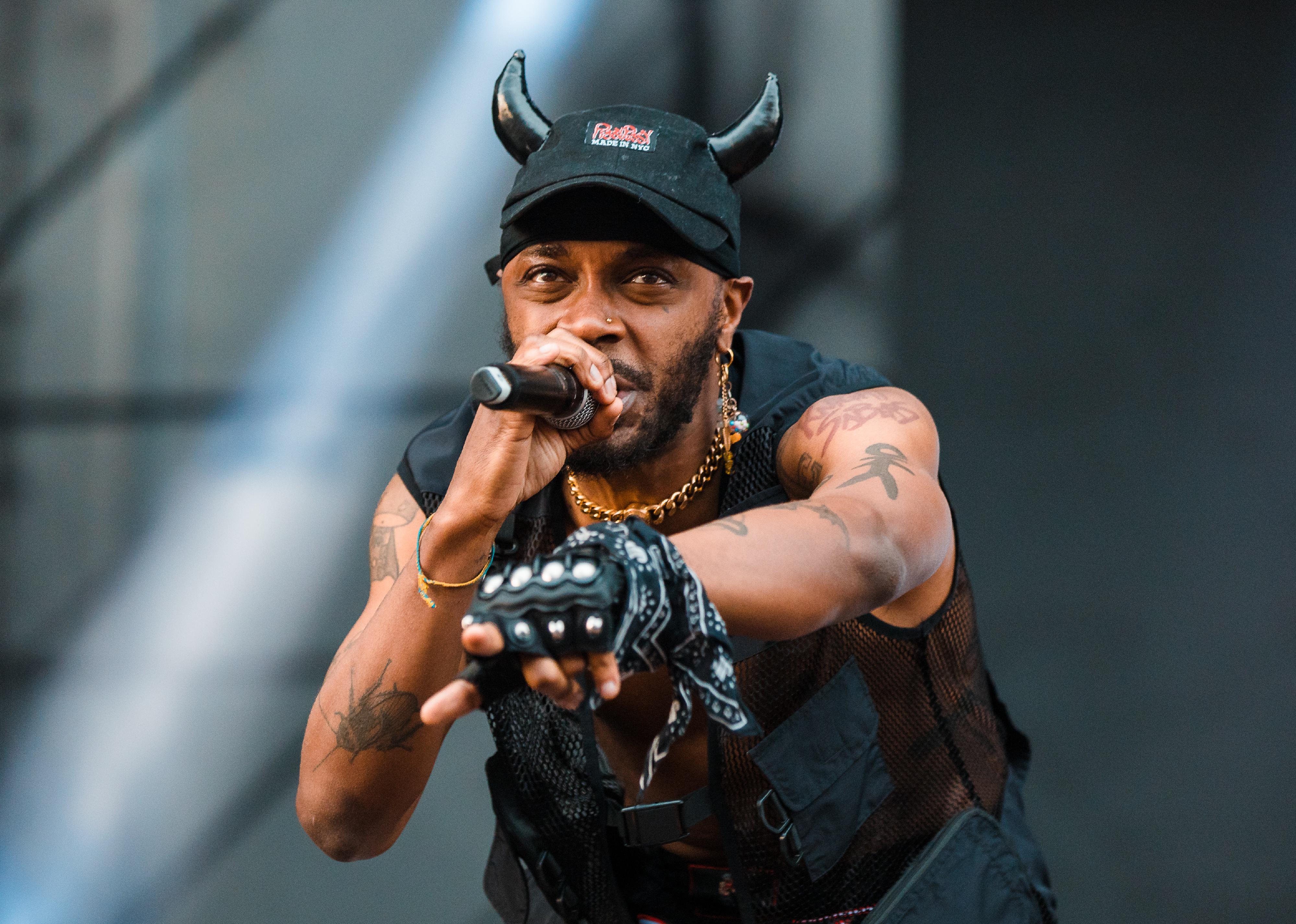 JPEGMAFIA performs onstage in a black hat with horns.
