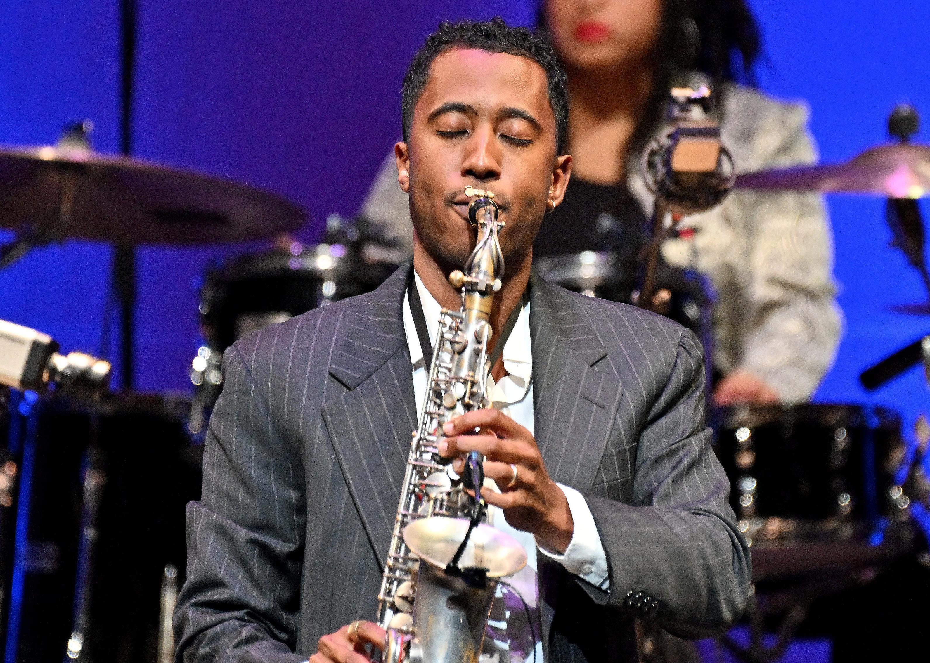 Braxton Cook playing the saxophone onstage.