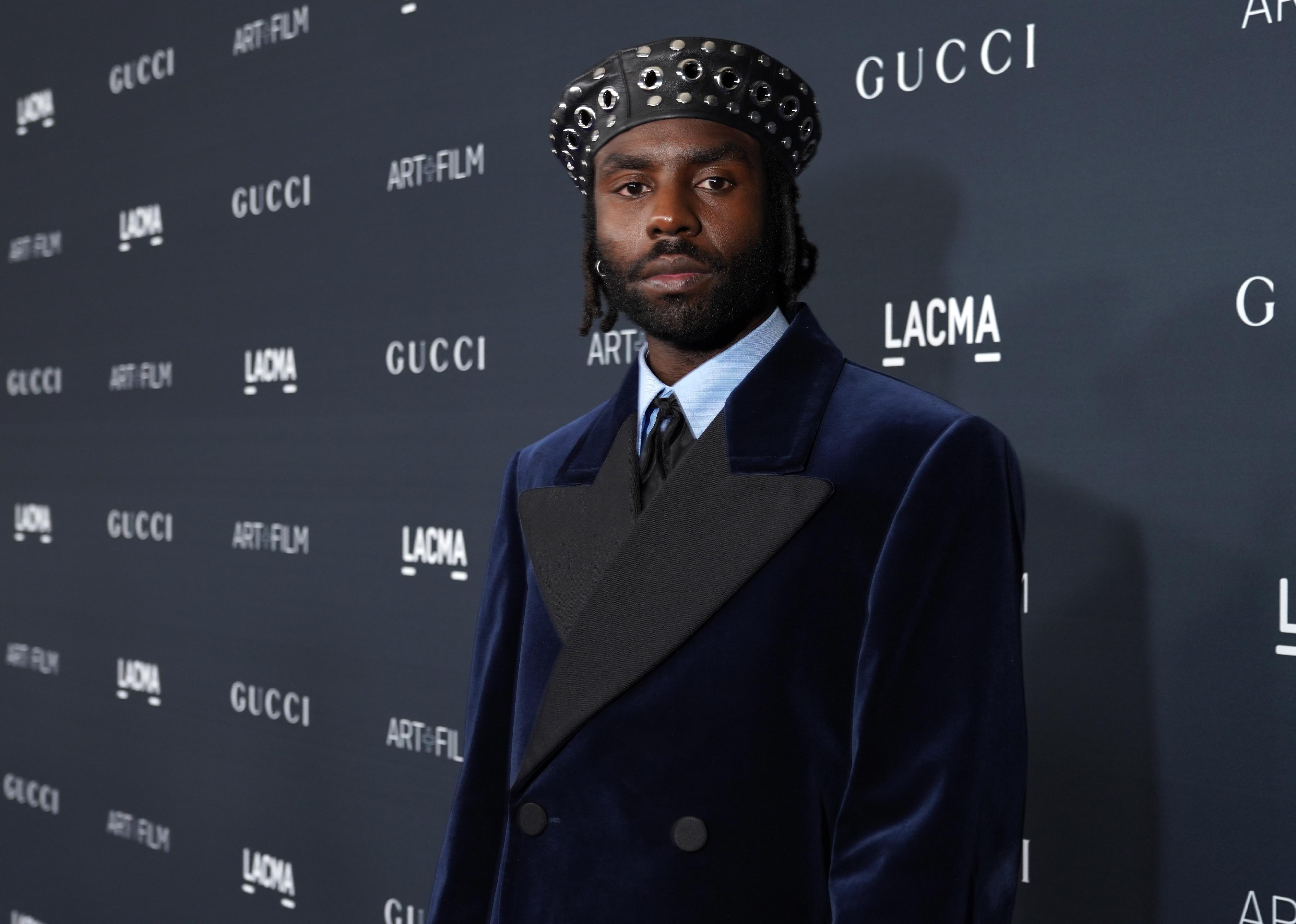 Dev Hynes of Blood Orange in a blue velvet suit and black leather hat.