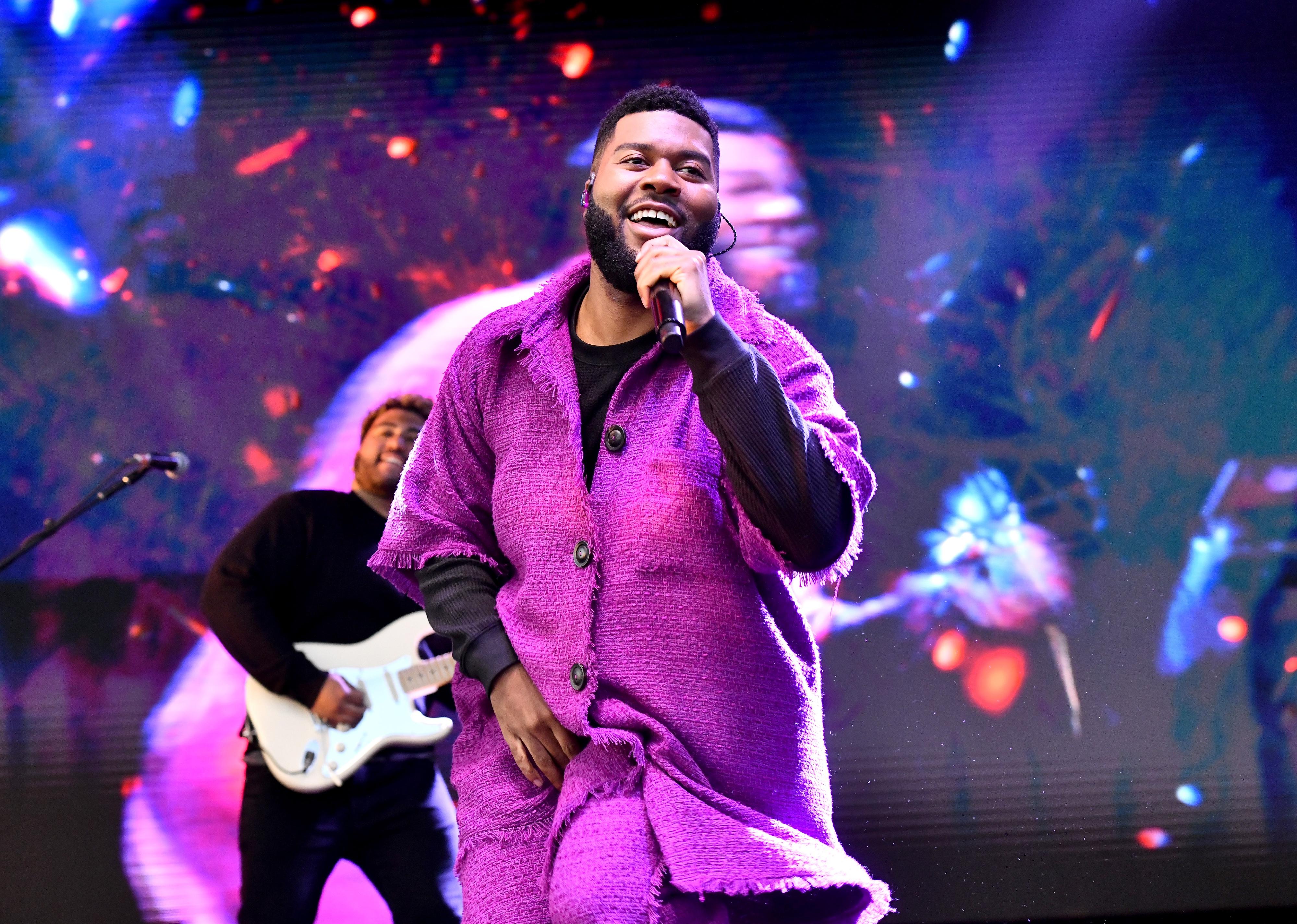 Khalid performing onstage in a purple suit.