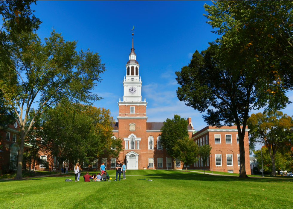 Students relax on the lawn before a clock tower on the campus of Dartmouth College.