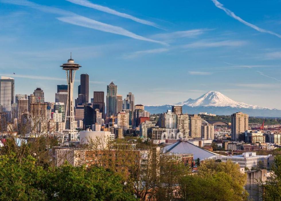 A view of Seattle with the Space Needle and snow-covered mountains in the background.