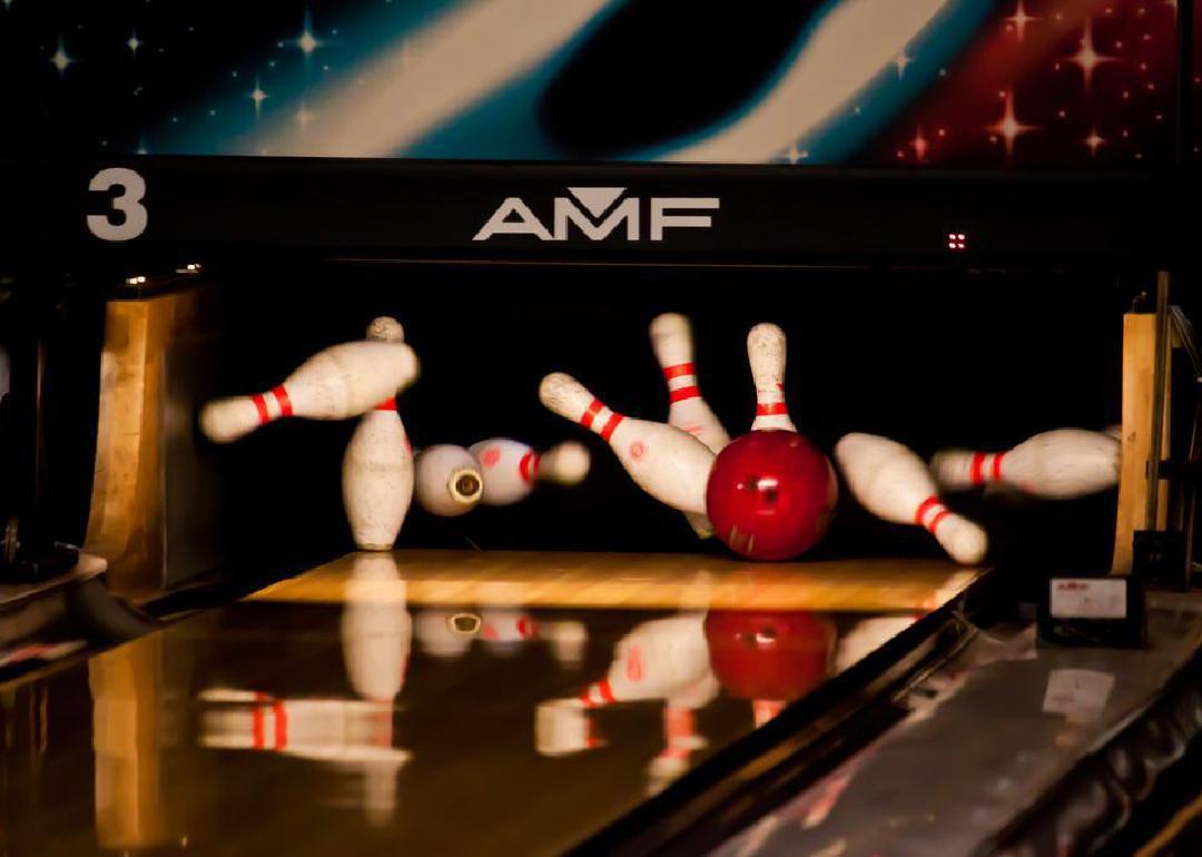 A red bowling ball hitting all of the pins. 