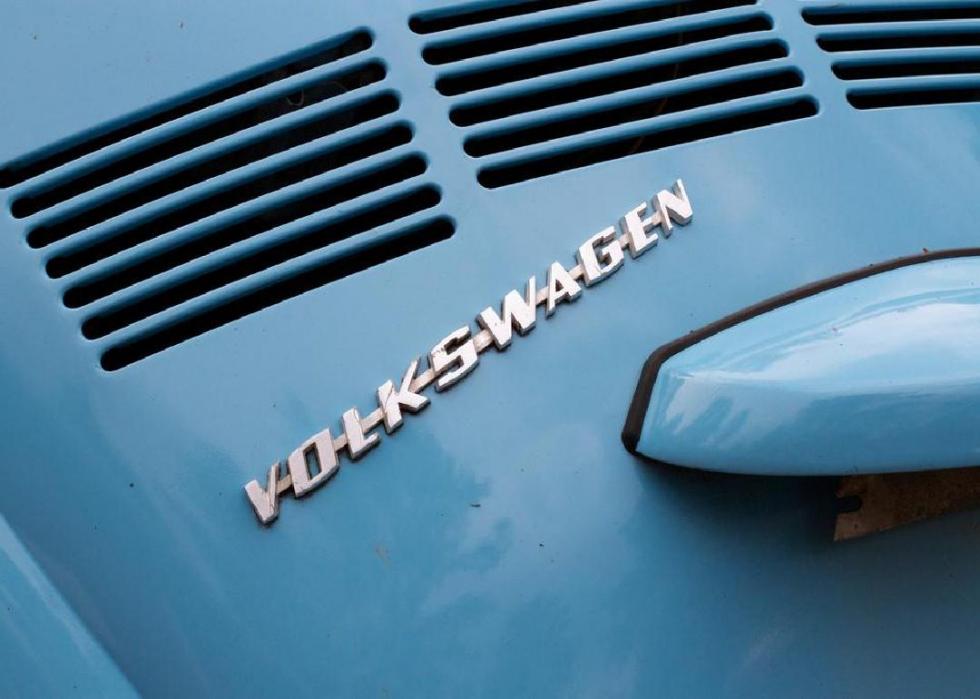 Close-up of Volkswagen sign on a blue car.