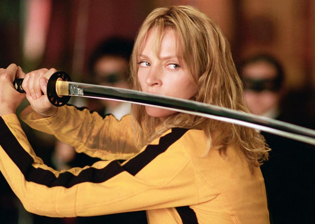 Uma Thurman holding a sword in a yellow and black jumpsuit.