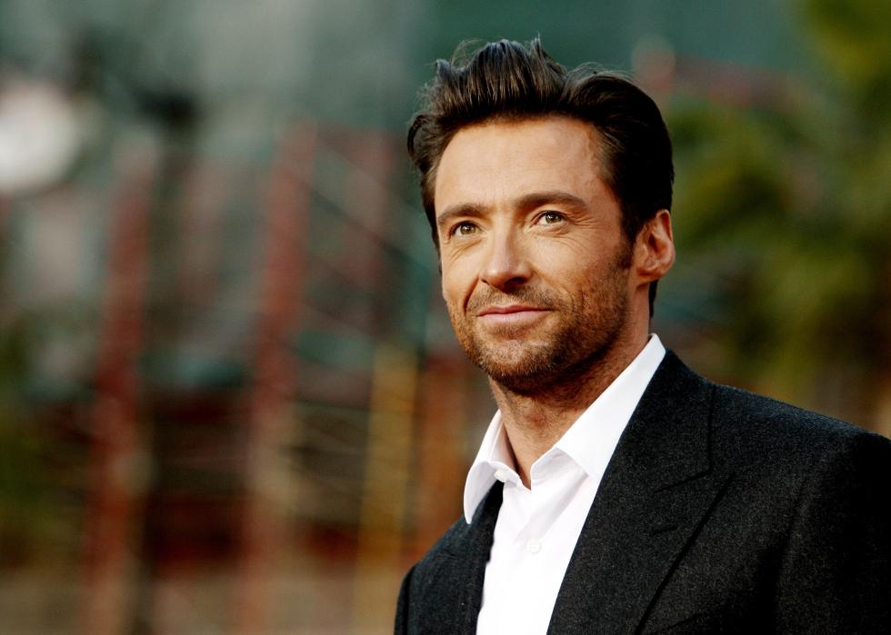 Hugh Jackman smiling while dressed in a suit.
