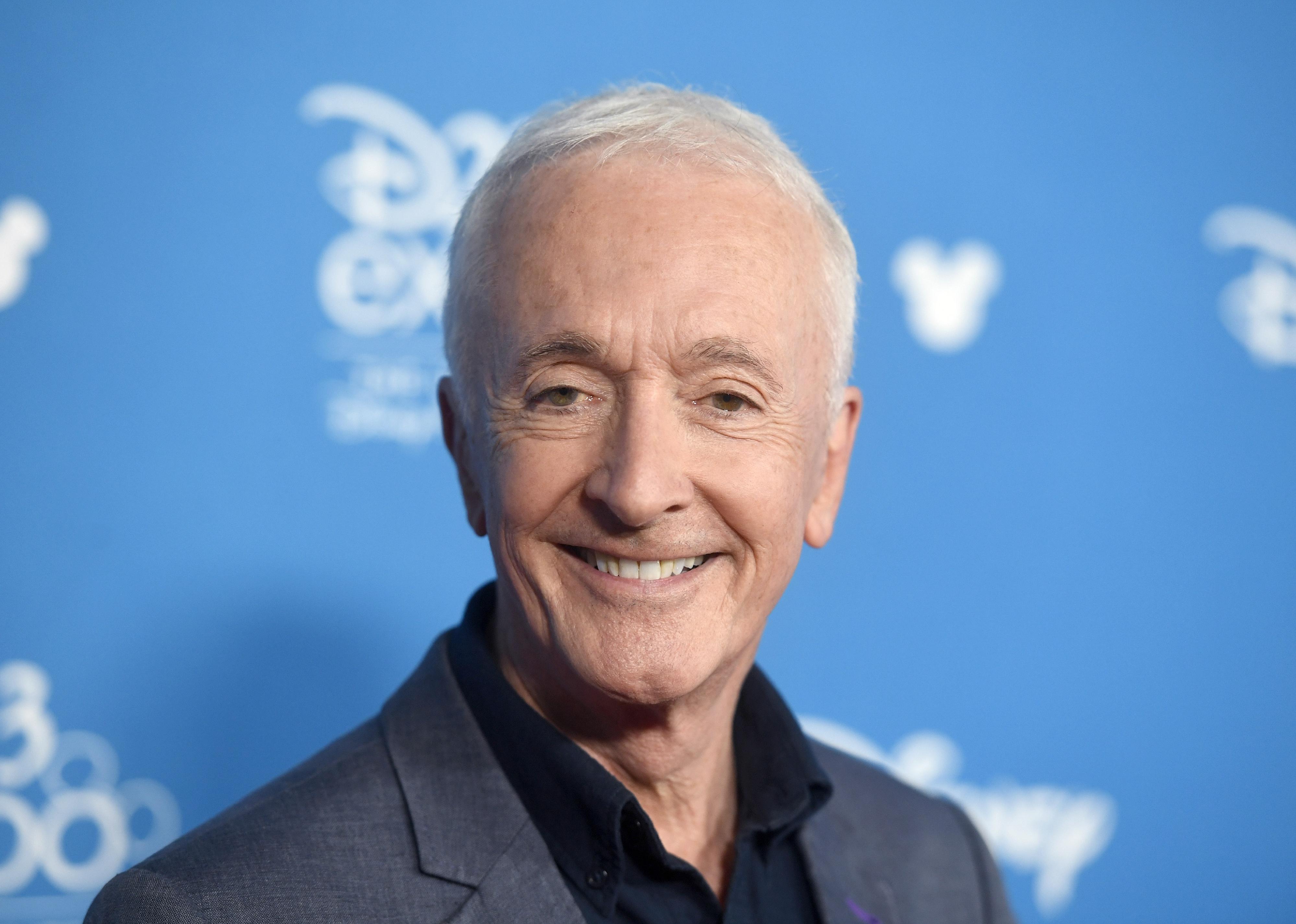 Anthony Daniels in a grey suit.