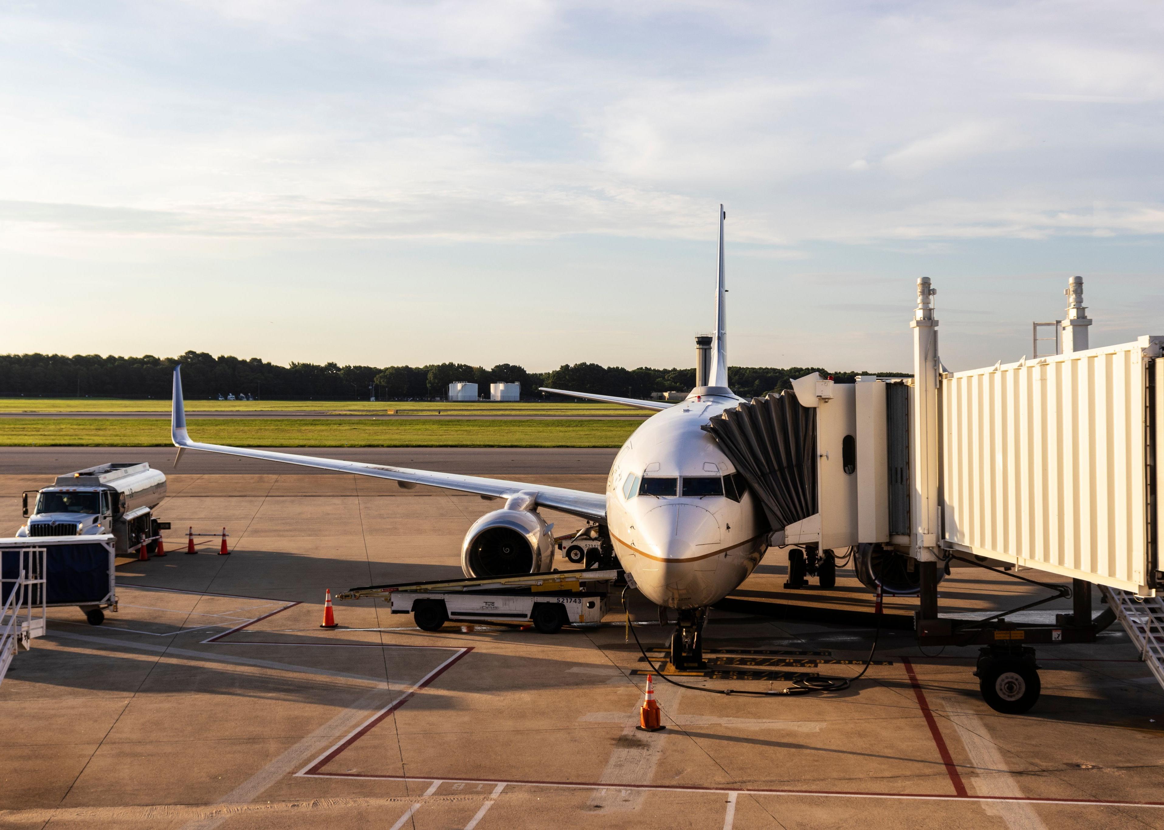 An airplane connected to a jet bridge at Norfolk airport.