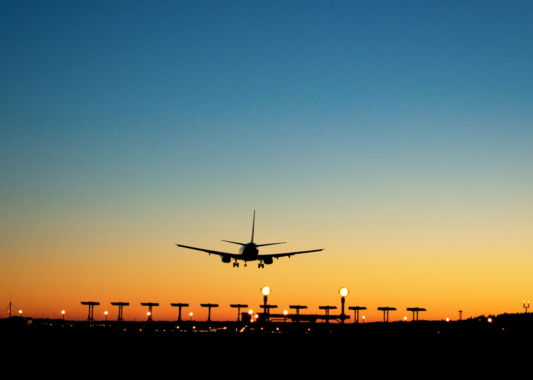 An aircraft approaching the runway at sunset.