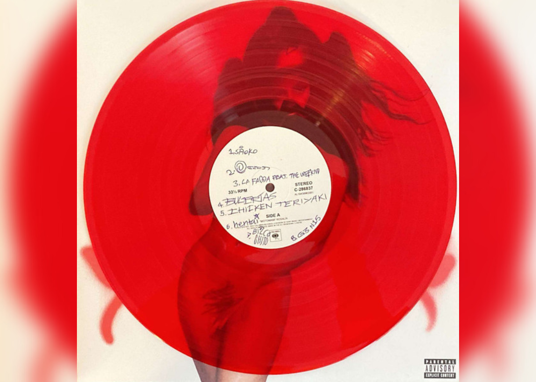 A red record with a nude woman blurred out in the background and handwritten notes over the song names.
