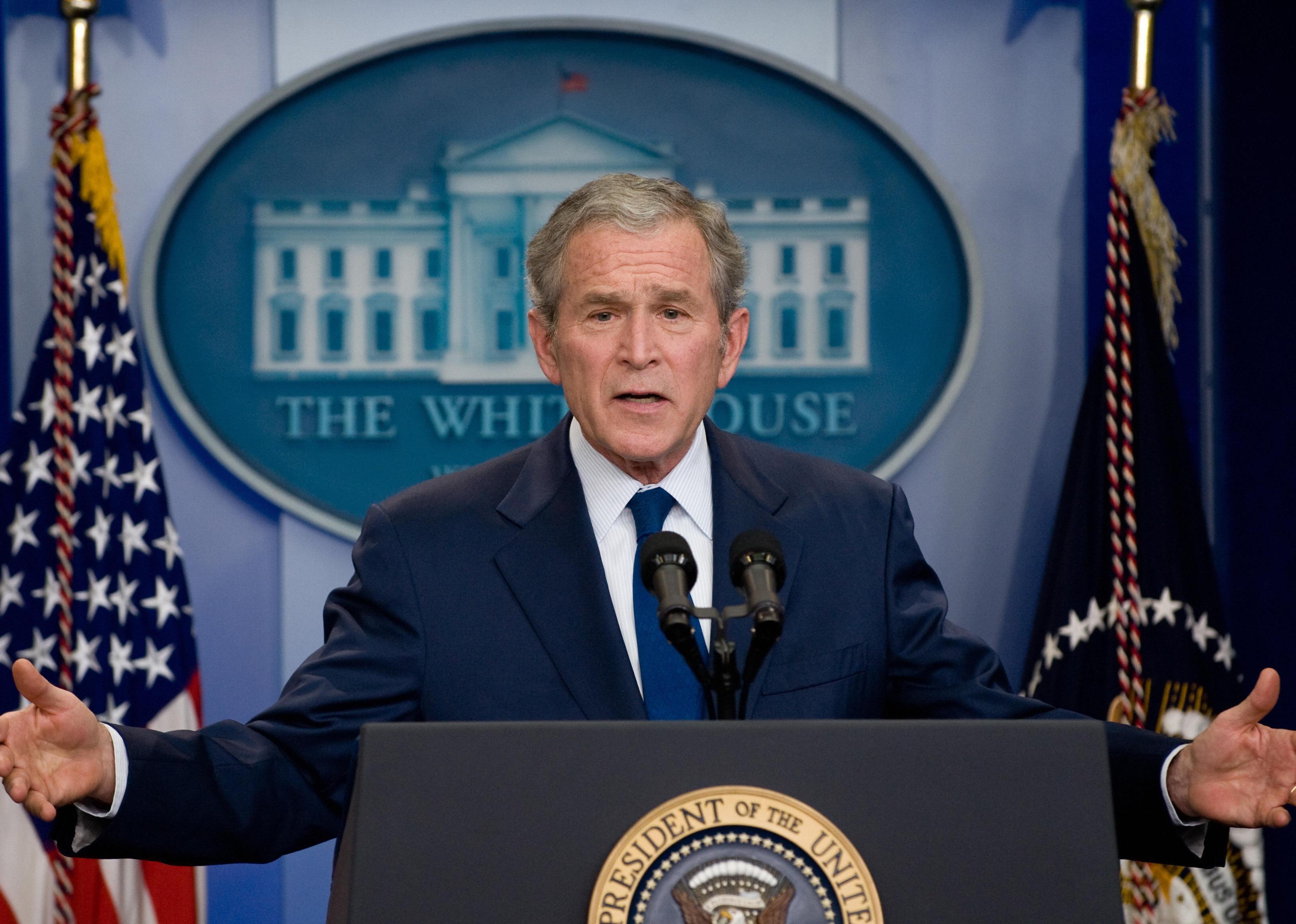 George W. Bush speaking at a podium at the White House.