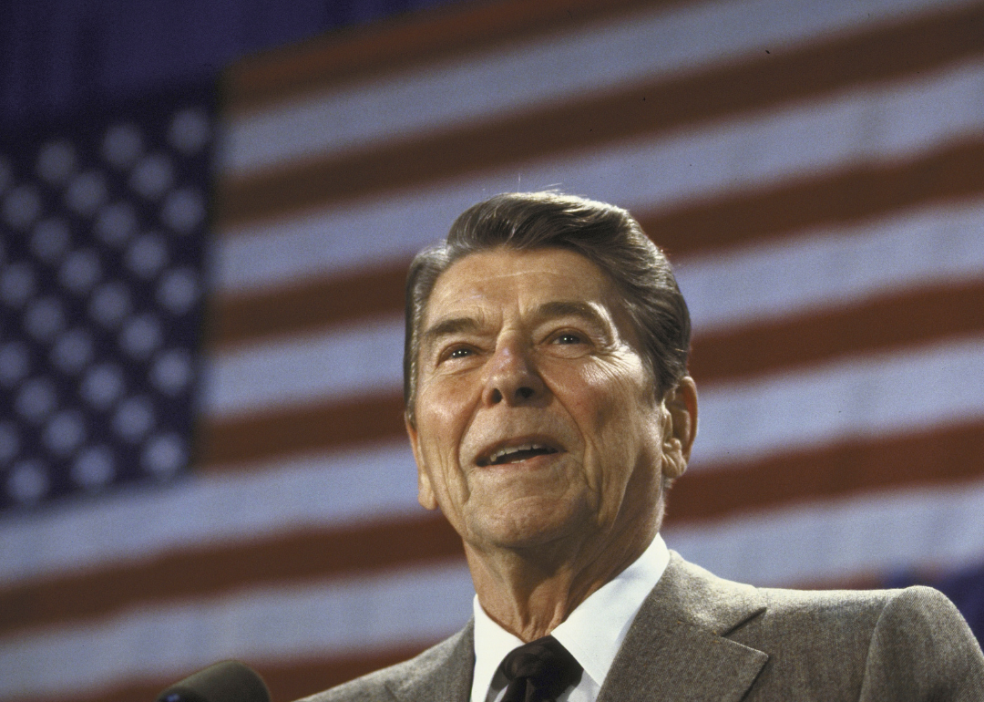 Ronald Reagan speaking in front of an American flag.