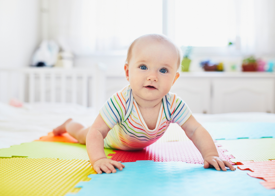 A baby on a colorful play mat.