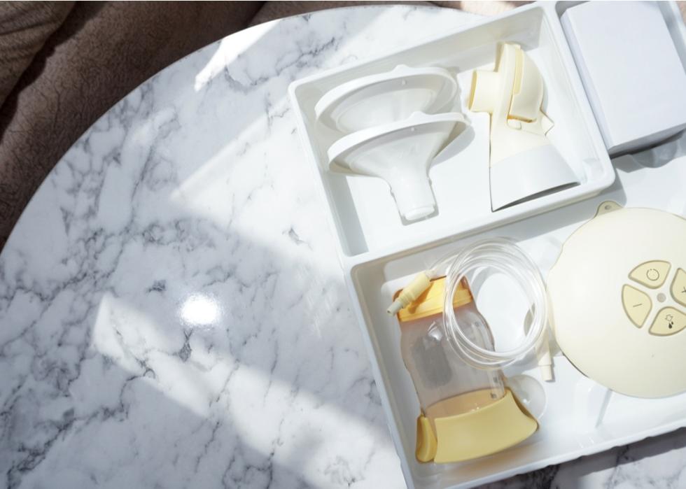 A breast pump in a box on a white marble table.