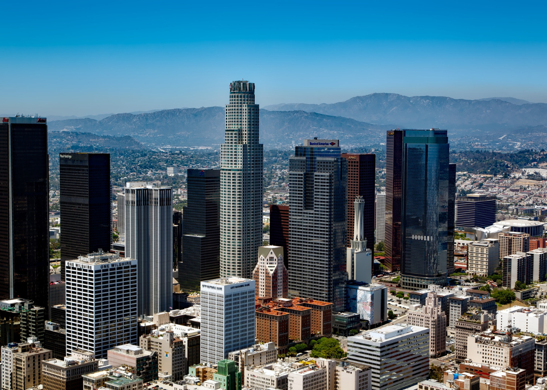 Tall buildings in downtown Los Angeles, CA surrounded by mountains.