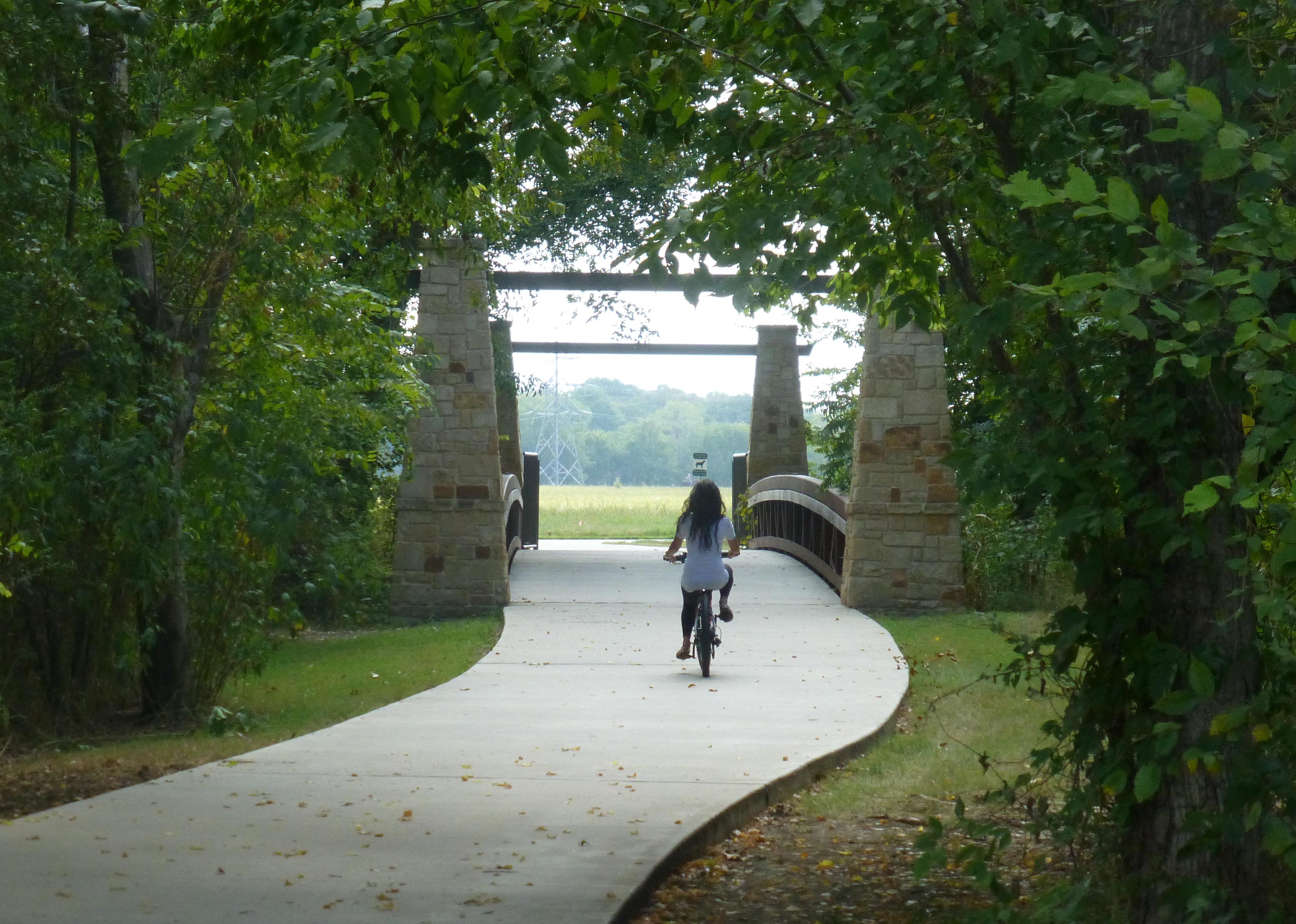 A woman riding a bike in a park.