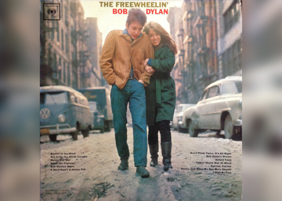 Bob Dylan walking arm in arm with a woman down the street.