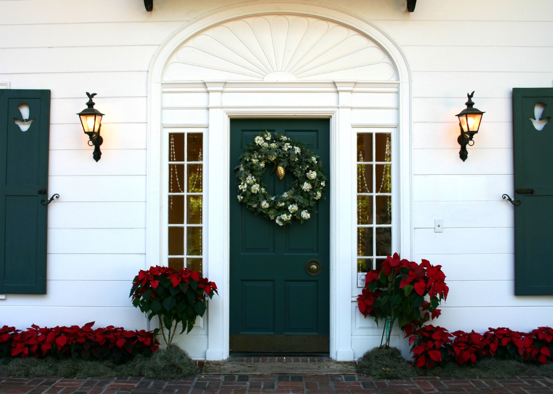 A colonial front door with green trim and a wreath.