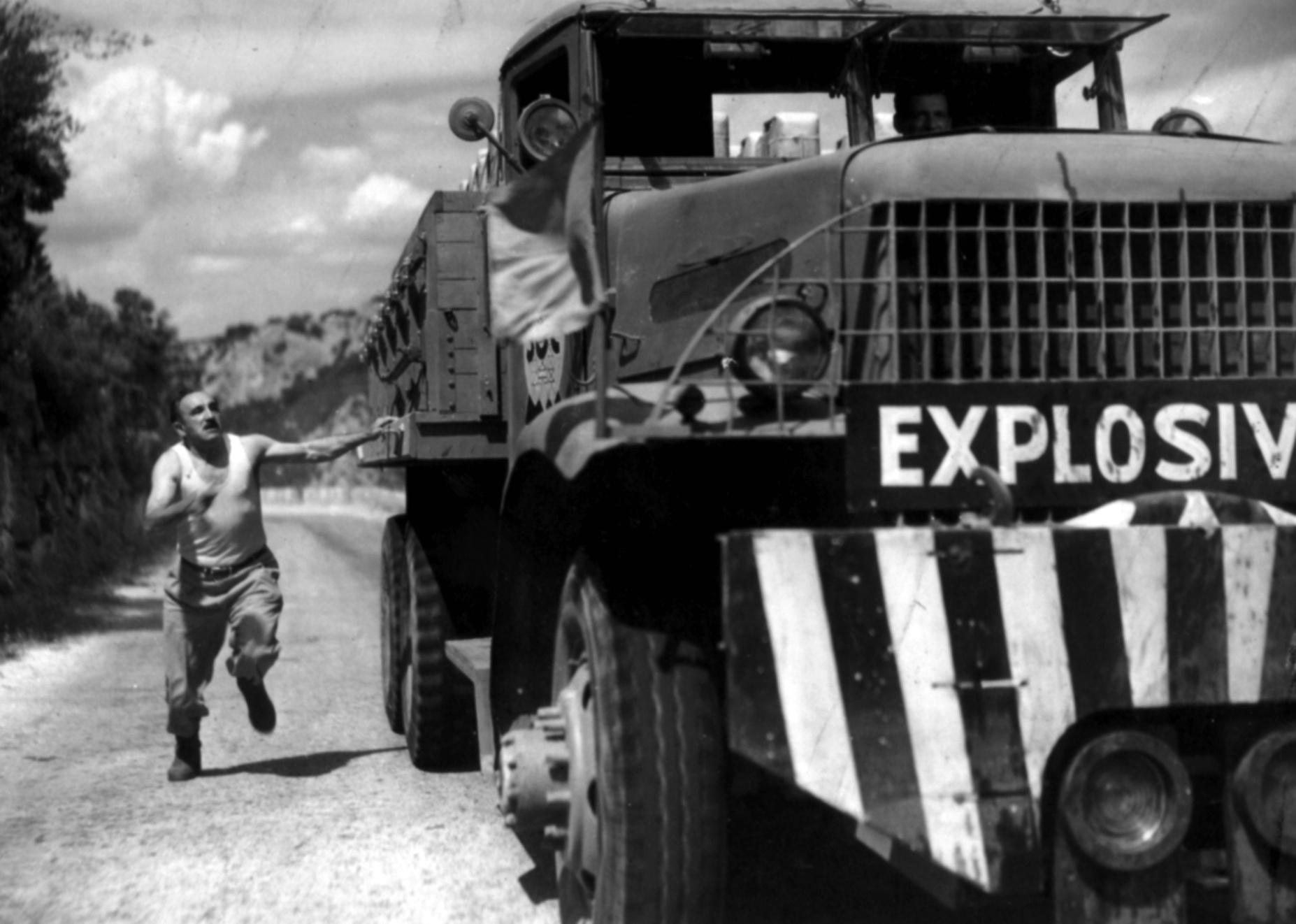 A man running next to a truck labeled as explosive.